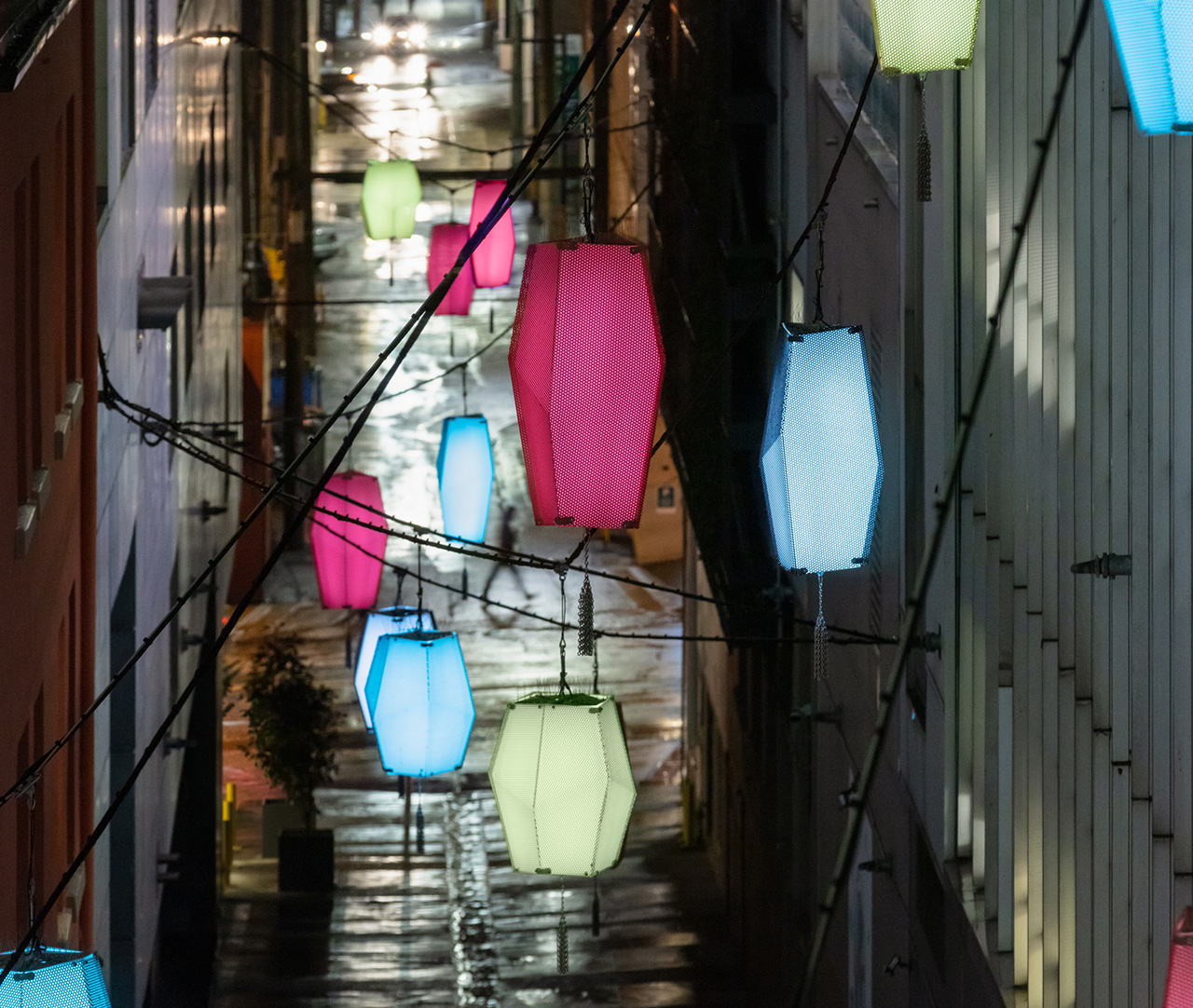 Detail image at dusk of Martin Boyce's art installation, Beyond the Sea, Against the Sun in the TELUS Garden laneway, which consists of a series of suspended lanterns.